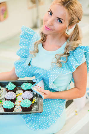 Smiling young housewife. Cooking baking in the kitchenの写真素材