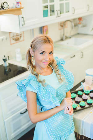 Smiling young housewife. Cooking baking in the kitchenの写真素材
