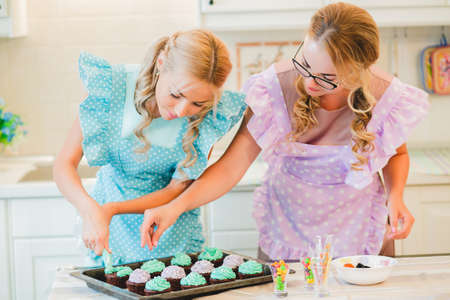 two women in the kitchen preparing food.の写真素材