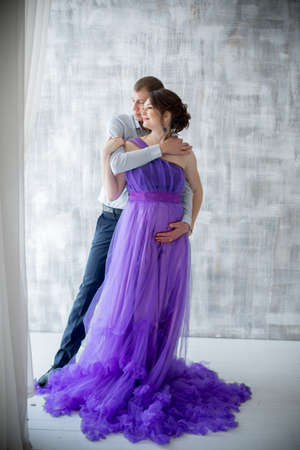 pregnant woman and man posing together in Studio, happy waitingの写真素材