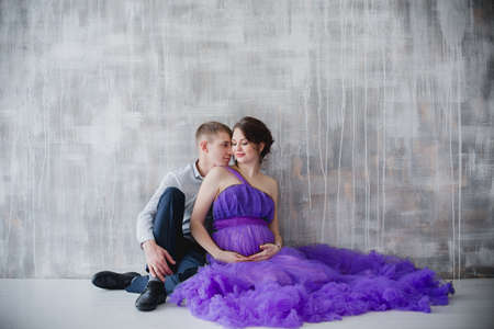 pregnant woman and man posing together in the Studioの写真素材