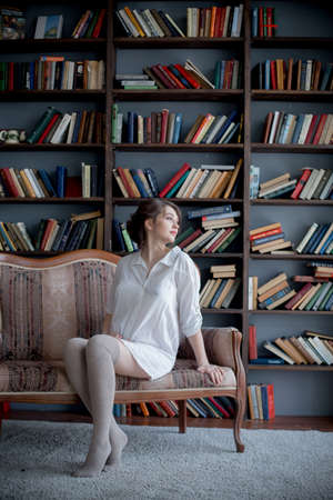 Portrait of a young pregnant woman in white shirt in photo Studioの写真素材