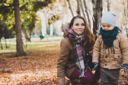 mother and baby playing in autumn Park outdoorsの写真素材