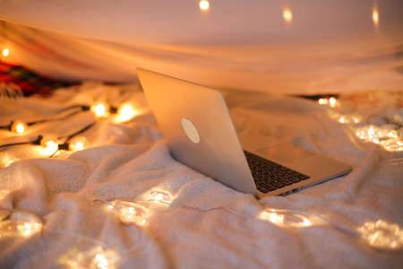 the laptop lies on the bed in the background of a Christmas-tree light,smooth movementの写真素材