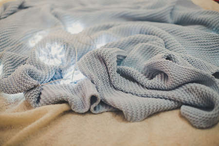 blue plaid lying on the bed, on the blanket lies the garland, the Christmas interior