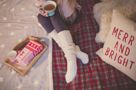 young woman in christmas interior. Sit with a plaid and a cup of tea.の写真素材