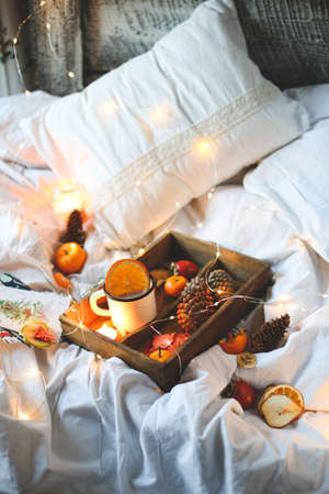 Christmas background dry oranges, sweet tangerines in a box, coffee in a white mug.の写真素材