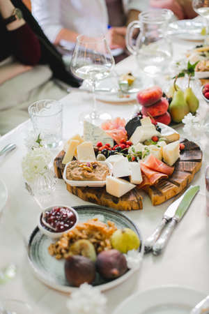 Beautifully decorated catering banquet table with different food snacks and appetizers with sandwich, caviar, fresh fruits on corporate party event or wedding celebrationの写真素材