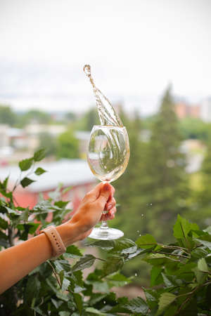Woman holding a wine glass on white background.の写真素材