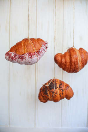 freshly baked croissants on wooden cutting board, top view