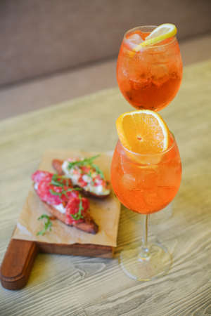 Refreshing mojito cocktail with garnet, mint and lime, on a dark gray stone table with shaker for whipping drinks.の写真素材