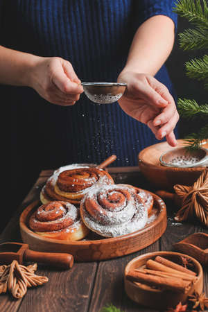 Homemade fresh cinnamon roll. Christmas cinnamon roll. pour flour or icing sugar on buns.の写真素材