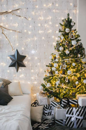 Close up a Christmas tree lights glittering at night. New Year fir tree with decorations and illumination. Xmas tree decorations background. Many large golden balls on fir tree New Year and Christmas.の写真素材