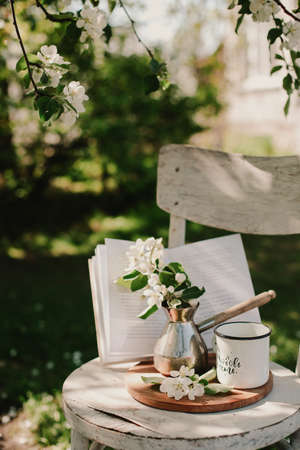 Novosibirsk city, 05/12/2020. composition with a cup of tea with a plaid and a book on a chair on a background of wood. breakfast in natureのeditorial素材