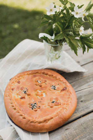 Top view of a pie with cabbage on a dark wooden table. Top view of a pie in a rustic style.