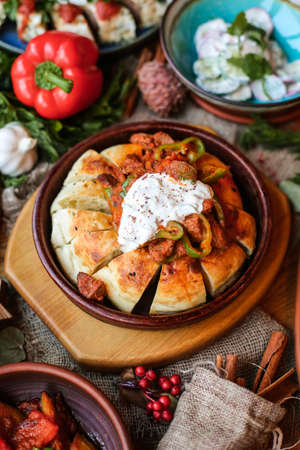 Muslim Ramadan iftar family dinner. Flat-lay of people feasting over table with Middle East food. Dates, dolma, kebab, flatbread, pide, borek, sweet, salad, top view. Ramazan fasting Turkish cuisine.の写真素材