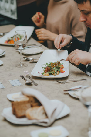 There is a salad close-up. hands properly hold cutlery in the restaurant. table etiquette.