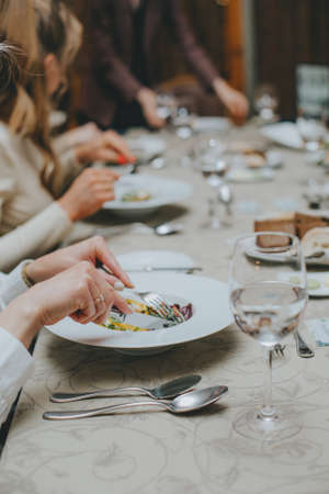 There is a salad close-up. hands properly hold cutlery in the restaurant. table etiquette.の写真素材
