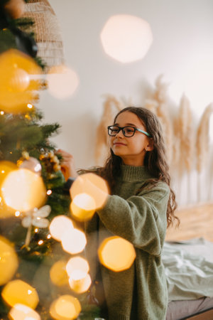 happy teenage girl sitting near christmas treeの写真素材