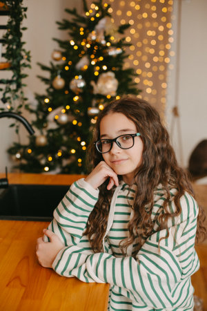 happy teenage girl sitting near christmas treeの写真素材