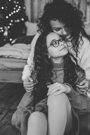 Happy young woman with cute teenage daughter in christmas interiorの写真素材