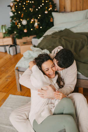 Young couple in a house in a romantic winter landscape in a christmas interiorの写真素材