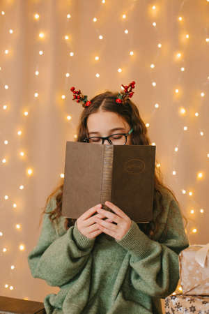 happy teenage girl sitting near christmas treeの写真素材