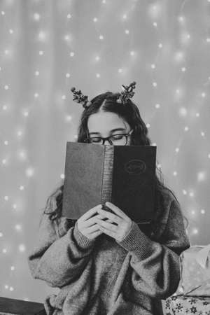 happy teenage girl sitting near christmas tree