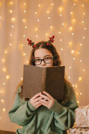happy teenage girl sitting near christmas treeの写真素材