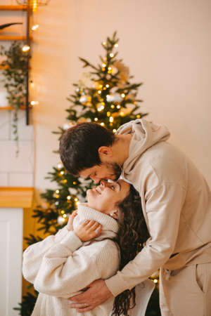 Young couple in a house in a romantic winter landscape in a christmas interiorの写真素材