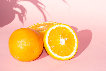 Orange fruit on pastel pink background. Minimal summer concept.の写真素材