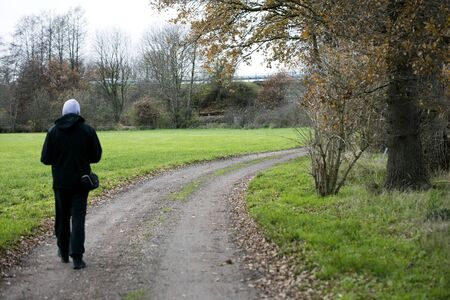 Man walking alone on forest road background fifty megapixels