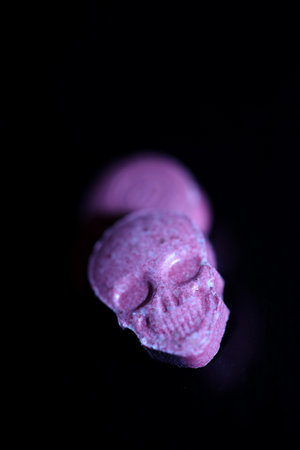 Pink skull ecstasy pill close up background high quality prints purple army dope narcotics substance high dose psychedelic way of lifeの写真素材