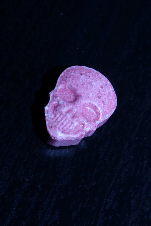 Pink skull ecstasy pill close up background high quality prints purple army dope narcotics substance high dose psychedelic way of lifeの写真素材