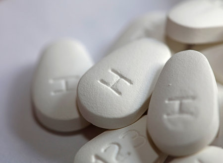 White pharmaceutical pills with numbers 123 and later h on back side close up medical modern...