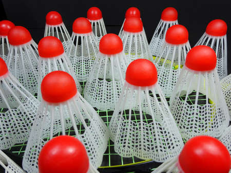 Red plastic shuttlecocks on badminton racketの写真素材