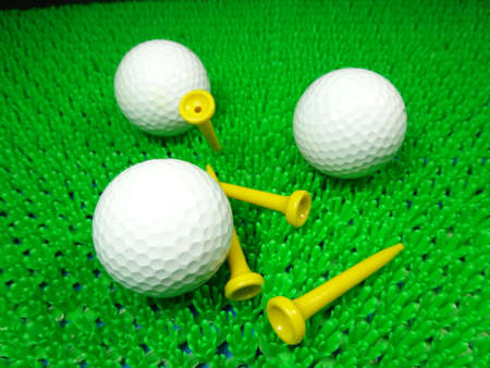 golf balls and tees on green fieldの写真素材