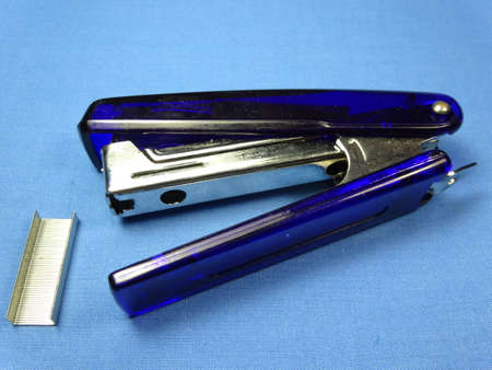 A blue stapler in blue background