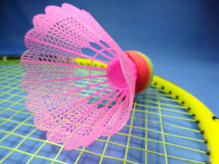 colourfull plastic shuttlecock  on badminton racket in blue  background. Photo taken in Malaysia, south east asiaの写真素材