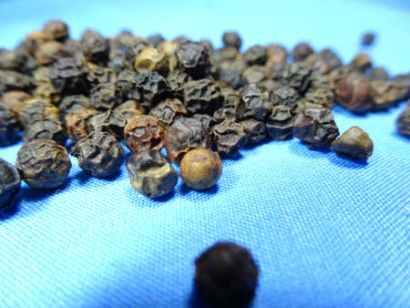 black pepper scattered in blue background, photo taken in Malaysiaの写真素材
