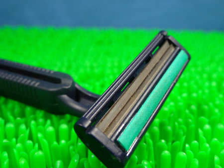 Razor in artificial green grass background. photo taken in Malaysiaの写真素材