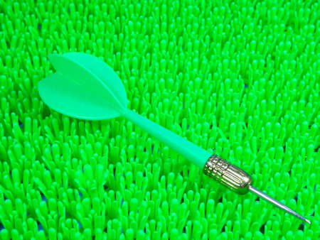 A green dart on  on artificial green grass backgroundの写真素材