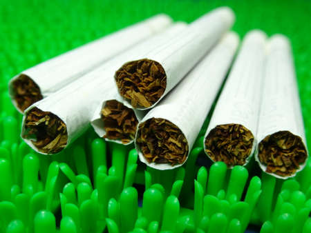 white menthol cigarette on artificial green grass backgroundの写真素材
