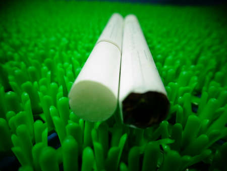 white menthol cigarette on artificial green grass background