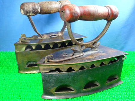 Malaysian antique cloth iron equipment on artificial green grass backgroundの写真素材