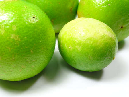 Unripe Key lime fruit close up on white background
