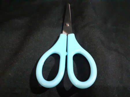 A blue scissor on black background. photo taken in Malaysia