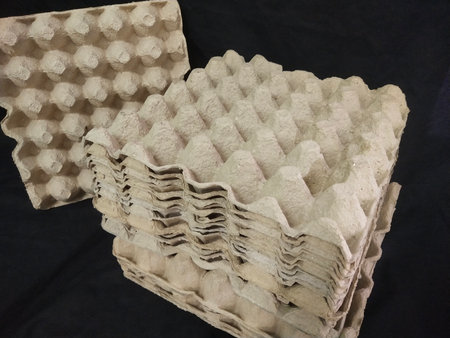 stacked egg empty paper cardboard  tray close-up on black background. photo taken in malaysia