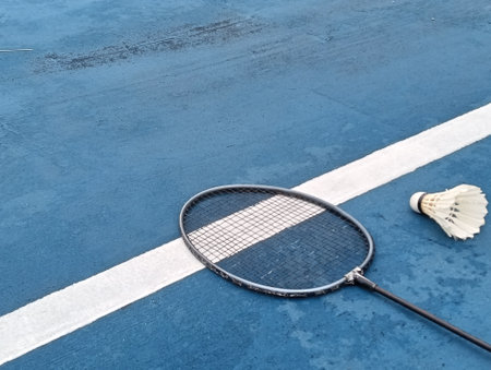 shuttlecock and badminton racket on a blue  badminton court outside the line on blue background close up. Photo taken in Malaysiaの写真素材