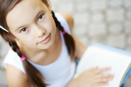 portrait of a cute young girl reading a bookの写真素材